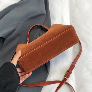 Vue détaillée du grand sac cabas en daim marron avec base rectangulaire et coutures soignées