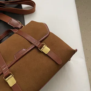 Detail of vintage caramel leather bag with gold buckles and suede texture stitching