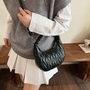 Detail showing the vertical pleated texture and silver hardware of the black hobo bag
