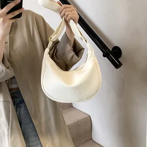 Détail du sac demi-lune blanc crème avec texture lychee et garnitures dorées