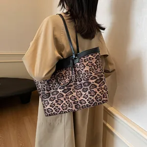 Detailed side view of large leopard print tote bag styled with a khaki trench coat