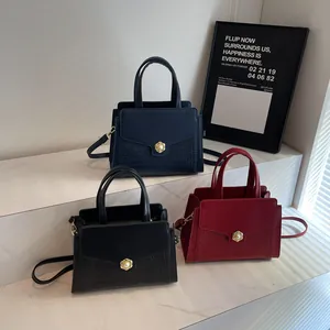 Three elegant leather handbags in blue black and burgundy colors displayed on marble