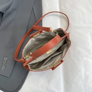Vue intérieure du sac cabas en cuir rouge brique avec compartiments et finitions dorées