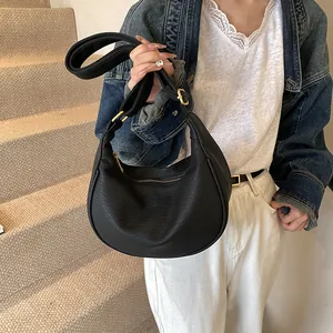 Détail du sac hobo noir texturé avec boucle métallique dorée et fermeture éclair élégante
