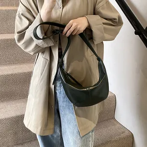 Primer plano de un bolso hobo de cuero minimalista con correa ajustable al hombro