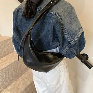 Detalle del bolso hobo negro en forma de media luna con correa ajustable al hombro