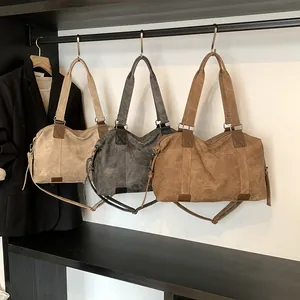 Sacs cabas vintage en cuir souple en beige, gris et marron exposés sur des supports
