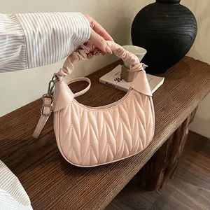 Detail of pink pleated cloud bag featuring wavy textures and a stylish ruched handle