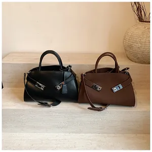 Detailed view of leather tote bags with distinctive silver metal horseshoe buckles on steps