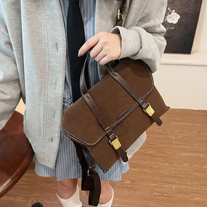 Detail of vintage suede and leather briefcase with buckles and contrast stitching