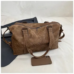 Gros plan du sac fourre-tout en toile marron foncé avec bandoulière et fermeture éclair