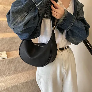 Vue détaillée du sac hobo croissant noir en cuir texturé avec des finitions dorées