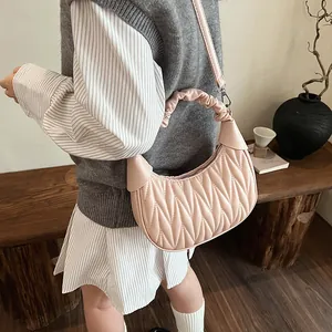 Detail of light pink pleated crescent bag showing quilted texture and ruched handle