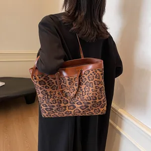 Close-up of contrast leopard print tote bag with premium brown leather straps