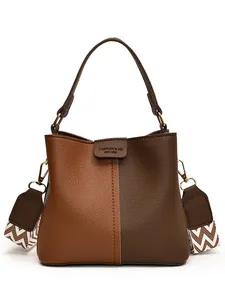 Retro two-tone leather bucket bag with wide chevron strap in brown and caramel