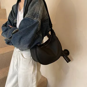 Vue détaillée d'un sac demi-lune noir en cuir texturé avec bandoulière réglable