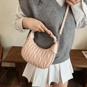 Detail showing pink quilted cloud hobo bag with adjustable strap on a female model