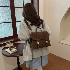 Side view of large vintage dark brown suede backpack with buckle closure and handle
