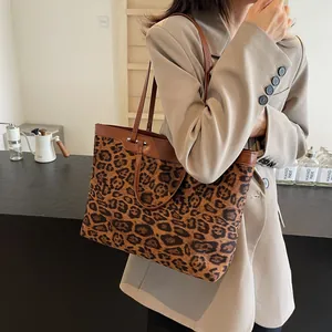 Detailed side view of large leopard print tote bag with premium leather handles on model