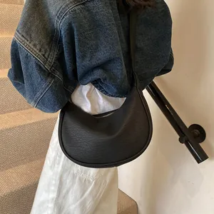 Vue détaillée du sac demi-lune noir avec texture grainée et fermeture éclair en métal