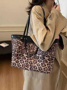 Leopard print tote bag with black leather straps shown on a model for a chic fall look