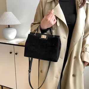 Détail du sac Kelly noir avec fermoir doré et bandoulière en cuir à deux textures