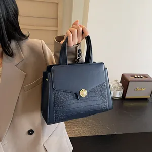 Detail of navy blue crocodile embossed leather handbag with vintage pearl metal buckle