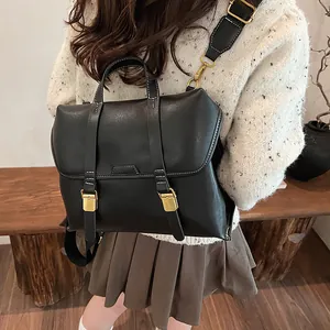Close-up of black PU leather backpack with gold buckles and contrast stitching detail