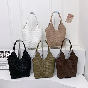 Collection of woven tote bags in five colors displayed on a minimalist white stage