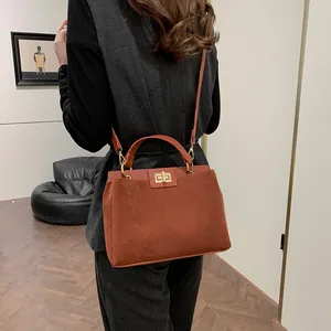 Sac Kelly en daim caramel vu de dos avec une bandoulière réglable sur le mannequin