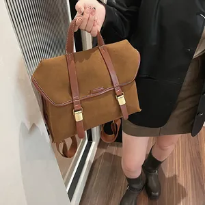 Close-up of vintage brown suede backpack with leather straps and gold metal buckles