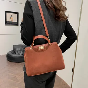 Sac bandoulière moderne en daim caramel porté par un mannequin dans un décor épuré
