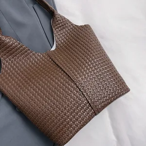 Close-up of deep brown woven leather texture on a spacious tote bag for daily commute