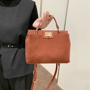 Détail du sac cabas rouge rouille avec fermoir rotatif et design en cuir patchwork