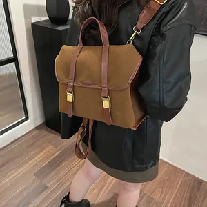 Back view of a large vintage brown suede backpack with dark leather straps on a model