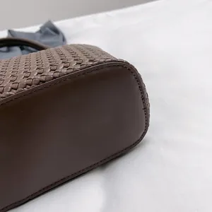 Detailed close-up of dark brown leather tote with intricate woven texture and fine stitching