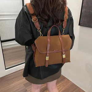 Detail of vintage brown matte suede backpack with polished leather straps and gold hardware