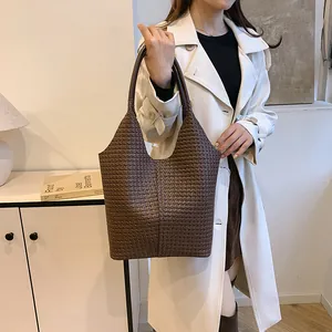 Detail of dark brown woven leather tote bag with long handles for daily commuting