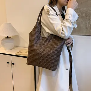 Close-up of dark brown woven tote bag featuring soft texture and stylish shoulder strap