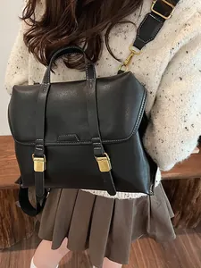 Retro black leather backpack with white stitching and gold buckle shown on a model