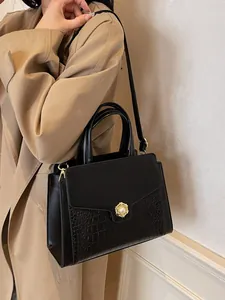 Black crocodile pattern leather tote bag with vintage pearl clasp shown on model