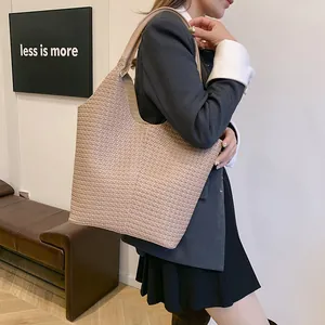 Detail of elegant taupe woven shoulder tote bag styled with a professional commute outfit