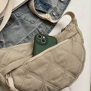 Detailed top view of beige quilted crescent bag showing spacious interior and phone storage