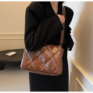 Détail d'un sac bandoulière matelassé marron avec texture en similicuir souple