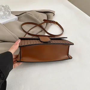 Detailed close-up of brown woven leather texture on a stylish vintage crossbody bag