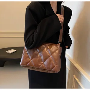 Gros plan d'un sac bandoulière marron en cuir matelassé avec un design à rabat élégant