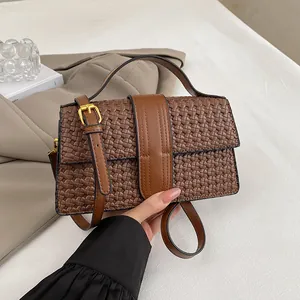 Detail of vintage brown woven texture on PU leather handbag with gold metal buckles