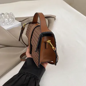 Detail shot of a dark brown woven evening bag featuring gold metal hardware and smooth leather