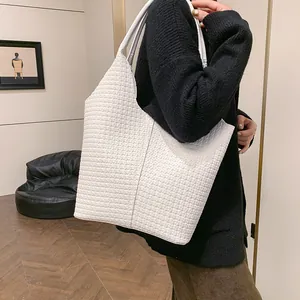 Detailed close-up of woven checkerboard texture on this white luxury shoulder tote bag
