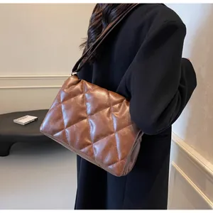 Détail du sac bandoulière matelassé marron foncé avec texture souple et grand motif à losanges